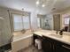 Bathroom featuring dual sinks, a walk-in shower, soaking tub, modern finishes and a vanity at 11660 Intervale Rd, Las Vegas, NV 89135