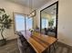 Dining room featuring a large wooden table, stylish chairs, modern lighting, and a decorative tree at 11660 Intervale Rd, Las Vegas, NV 89135