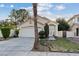 Charming single-story home features a well-manicured lawn, front garden, and an attached two-car garage at 1229 Triumph Ct, Las Vegas, NV 89117