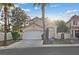 A single Gathering home with a well manicured front yard, driveway, and mature landscaping at 1229 Triumph Ct, Las Vegas, NV 89117