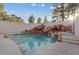Backyard pool area featuring a rock waterfall with slide and ample space for entertaining at 1229 Triumph Ct, Las Vegas, NV 89117
