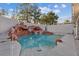 Outdoor pool features a unique rock waterfall, complemented by serene landscaping at 1229 Triumph Ct, Las Vegas, NV 89117