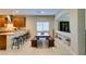 A view of the spacious kitchen with light tile floors, dark cabinets and wood dining table at 124 Strone St, Henderson, NV 89012