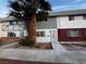 Inviting townhome featuring colorful siding, mature palm trees, and a well-maintained walkway at 150 Greenbriar Townhouse Way, Las Vegas, NV 89121