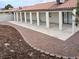 Spacious covered back patio with large support posts, concrete flooring, and decorative rock landscaping at 1608 Joshua Tree Ct, Las Vegas, NV 89108