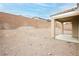 A rear exterior view of a home with a covered patio, blank canvas backyard, and privacy wall at 187 Golden Crown Ave, Henderson, NV 89002