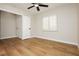 Bedroom featuring a ceiling fan, wood-style flooring, a window with shutters, and an interior door at 187 Golden Crown Ave, Henderson, NV 89002