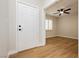 Entryway featuring a white door with black hardware and a view into a bedroom with a ceiling fan at 187 Golden Crown Ave, Henderson, NV 89002