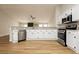 Modern kitchen featuring white cabinets, stainless steel appliances, and wood-look flooring at 187 Golden Crown Ave, Henderson, NV 89002