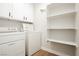 Functional laundry room with washer, dryer, white cabinets, and shelving at 187 Golden Crown Ave, Henderson, NV 89002