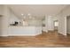 Open-concept living room featuring wood floors and white walls connected to the kitchen with white cabinets at 187 Golden Crown Ave, Henderson, NV 89002