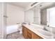 This bathroom has double sinks with wood cabinets and a large mirror at 1970 Jasper Creek Pl, Las Vegas, NV 89123