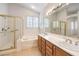 Bright bathroom featuring double sinks, a soaking tub, and a separate glass-enclosed shower at 1970 Jasper Creek Pl, Las Vegas, NV 89123