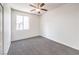 This bright bedroom features neutral carpet, a ceiling fan, and a window for natural light at 1970 Jasper Creek Pl, Las Vegas, NV 89123