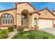 Charming home exterior featuring an arched entryway, desert landscaping, and two car garage at 1970 Jasper Creek Pl, Las Vegas, NV 89123