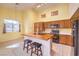 Bright, airy kitchen with wood cabinets, black appliances, and eat-in area at 1970 Jasper Creek Pl, Las Vegas, NV 89123