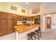 Well-lit kitchen with wood cabinets, a butcher block island with seating, and black appliances at 1970 Jasper Creek Pl, Las Vegas, NV 89123