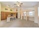 Open-concept living area with kitchen, bar, carpet, and natural light, ideal for entertaining at 1970 Jasper Creek Pl, Las Vegas, NV 89123