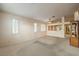 Open living room featuring carpet flooring, a ceiling fan, and plantation shutters at 1970 Jasper Creek Pl, Las Vegas, NV 89123