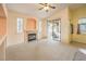 Bright living room featuring fireplace, slider to patio, neutral carpeting, and shuttered windows at 1970 Jasper Creek Pl, Las Vegas, NV 89123
