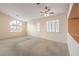 Open living room featuring carpet flooring, a ceiling fan, and a large arched window at 1970 Jasper Creek Pl, Las Vegas, NV 89123