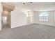 Open living room with arched windows, neutral paint, and plush carpet at 1970 Jasper Creek Pl, Las Vegas, NV 89123
