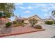 Single story home with a two-car garage, tile roof and desert landscaping at 213 Red Coral Dr, Henderson, NV 89002