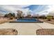Backyard with a rectangular pool surrounded by concrete and desert landscaping at 2281 Wagon Ave, Pahrump, NV 89048