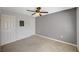 A cozy bedroom features neutral carpet, a ceiling fan, and two entry doors at 231 W Horizon Ridge Pkwy # 426, Henderson, NV 89012