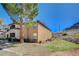 Exterior of a condominium complex with desert landscaping, a lawn, and a large tree in a sunny setting at 231 W Horizon Ridge Pkwy # 426, Henderson, NV 89012