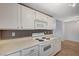 Efficient kitchen design with white cabinets, appliances, and vinyl flooring with ample storage at 231 W Horizon Ridge Pkwy # 426, Henderson, NV 89012