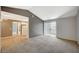 Living room featuring neutral carpet, gray walls, a sliding glass door, and an opening to the kitchen at 231 W Horizon Ridge Pkwy # 426, Henderson, NV 89012