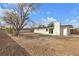Expansive backyard featuring a modern home with a patch of green grass and mature tree at 2837 Reynolds Ave, North Las Vegas, NV 89030