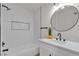 Modern bathroom showcasing herringbone tile, sleek fixtures, and a stylish round mirror at 2837 Reynolds Ave, North Las Vegas, NV 89030