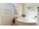 Bright bathroom features a soaking tub with a glass block window and modern fixtures at 3040 Ocean Port Dr, Las Vegas, NV 89117