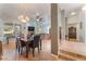 Open concept dining room with modern chandelier, wood table and view into living room at 3040 Ocean Port Dr, Las Vegas, NV 89117