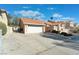 Single-story home featuring a two-car garage, a well-maintained yard, and a gated driveway at 3040 Ocean Port Dr, Las Vegas, NV 89117
