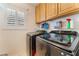 Bright laundry room with modern washer and dryer, overhead cabinets, and a window at 3040 Ocean Port Dr, Las Vegas, NV 89117