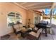 Covered patio with comfortable seating, a grill, and views of the landscaped backyard at 3040 Ocean Port Dr, Las Vegas, NV 89117