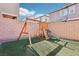 Backyard with a wooden swing set and slide, sitting on artificial turf at 457 Cornelius Kelly Ave, Henderson, NV 89011
