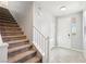 Bright foyer featuring tile flooring, staircase, and a front door view with natural light streaming through at 457 Cornelius Kelly Ave, Henderson, NV 89011
