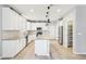 A well-lit kitchen features a central island, stainless steel appliances, and ample counter space at 457 Cornelius Kelly Ave, Henderson, NV 89011