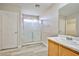 Bathroom features glass shower, wood vanity and bright lights at 4817 Eureka Diamond Ct, Las Vegas, NV 89139