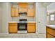 Efficient kitchen design features light wood cabinets, black appliances and direct view to the living area at 4817 Eureka Diamond Ct, Las Vegas, NV 89139