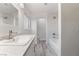 Updated bathroom features marble-look tile, grey wood-look flooring, and ample vanity storage at 539 Sellers Pl, Henderson, NV 89011