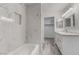 Recently renovated bathroom featuring marble-look tile, grey wood-look flooring, and modern fixtures at 539 Sellers Pl, Henderson, NV 89011
