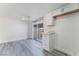 Bright kitchenette features white cabinets, grey wood-look flooring, and sliding glass doors to the backyard at 539 Sellers Pl, Henderson, NV 89011