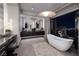 Elegant bathroom with double vanity, soaking tub, and access to a private outdoor space with city views at 545 Overlook Rim Dr, Henderson, NV 89012