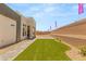 Newly landscaped backyard featuring artificial turf, stone pathways, desert landscape, and low block wall at 5719 Christian Creek Ct, Las Vegas, NV 89149