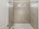 Modern tub shower with a window, tiled walls, and chrome fixtures for a spa-like bathroom experience at 5719 Christian Creek Ct, Las Vegas, NV 89149
